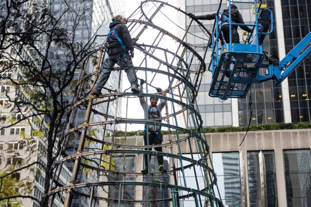  Workers disassemble a Tree in New York to illustrate Main graduate school admissions test revised as use drops by half