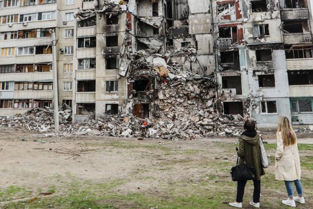 People looking at damaged residential buildings in Ukraine to illustrate I’ve finally quit the UCU after its hard-left motion on Ukraine war