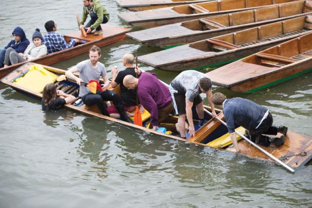 Cambridge University students trying to get into a boat on the River Cam in Cambridge as a metaphor for NCH clings to ‘Oxbridge’ dream