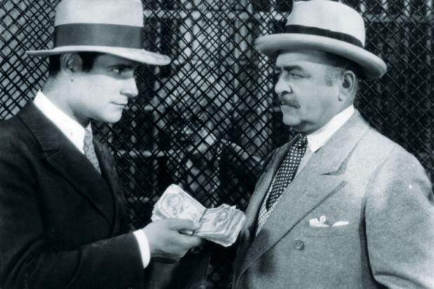 Victor Varconi (1896-1976) handing money to the lawyer in a scene from the film 'Chicago' as a metaphor for Sheffield ‘turned down £10 milllion’ for apprenticeships