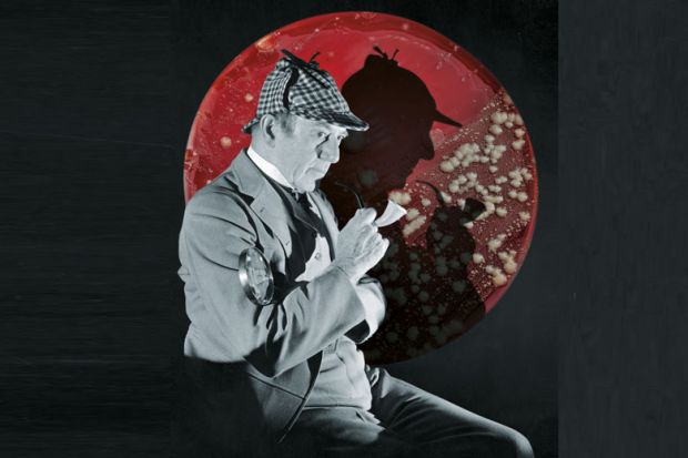 Studio portrait of a man dressed as British detective Sherlock Holmes with a plaid cap, a meerschaum pipe, and a magnifying glass. His silhouette is visible in the background
