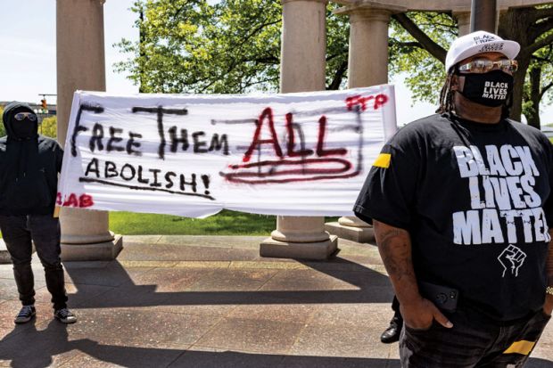 Black Lives Matter activist stands in front of other activists that advocate for abolishing the police during a rally against police brutality in front of the Columbus City Hall in Columbus, Ohio on May 1, 2021