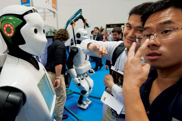 Two visitors check out humanoid robot REEM of Spanish engineering company PAL Robotics at the Automatica trade fair in Munich, southern Germany 