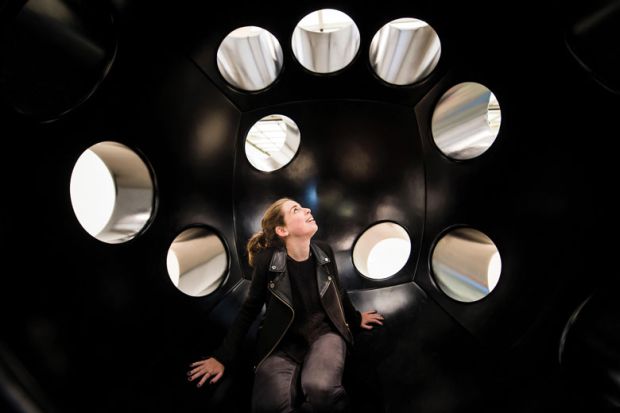 Woman sitting in an art installation looking at the holes Woman sitting in an art installation looking at the holes to illustrate don’t fear losing Elsevier access, California negotiator tells UK