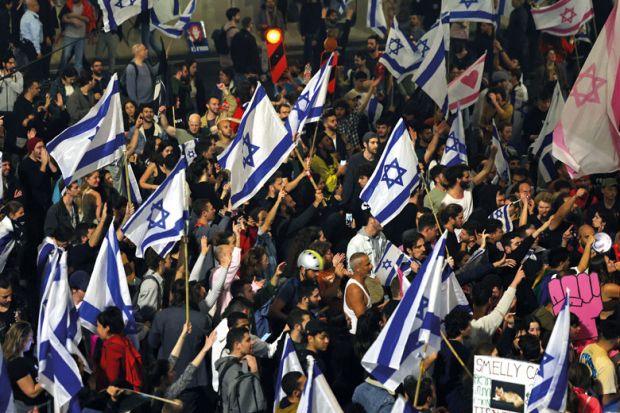 Protesters block a road and hold national flags during a rally to illustrate Israel crisis: university presidents ‘ready to strike again or sue’