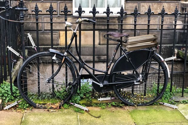 Old style bicycle with flat tyres chained up on fence railings with syringes around the wheels to illustrate Social research is being stymied by excessive ethical oversight