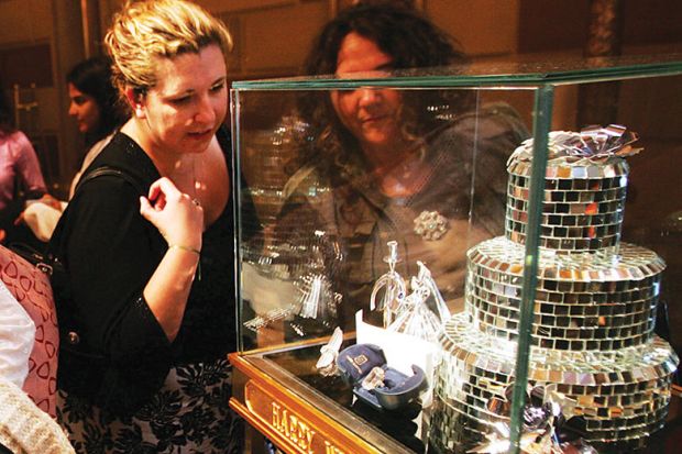 Two people look at a case of one of the world's largest diamonds in New York City as a metaphor for Biden’s $300 billion campaign promise met with scepticism.