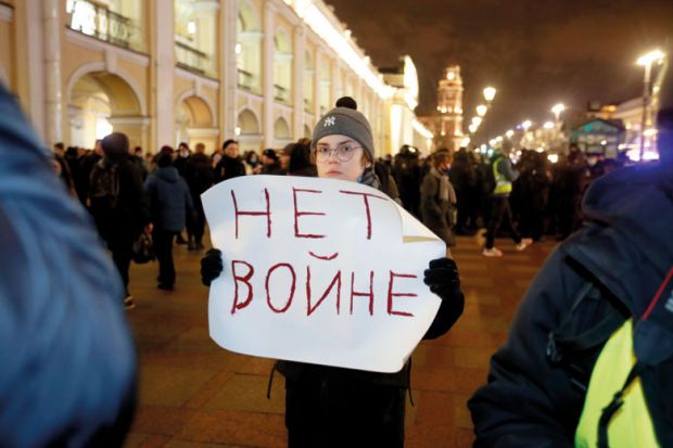 demonstrator holds a banner during an anti-war protest in Saint Petersburg, Russia to illustrate Russia punishes anti-war stance with expulsions