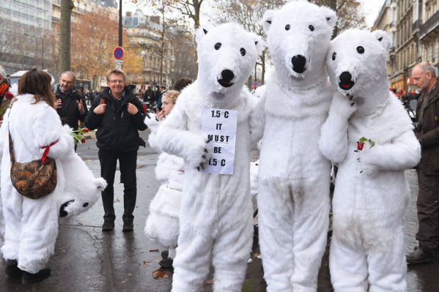 People wearing polar bear costumes are seen while activists stage a climate change demonstration near the Arc de Triomphe to illustrate Mandatory climate courses gain popularity, but challenges too