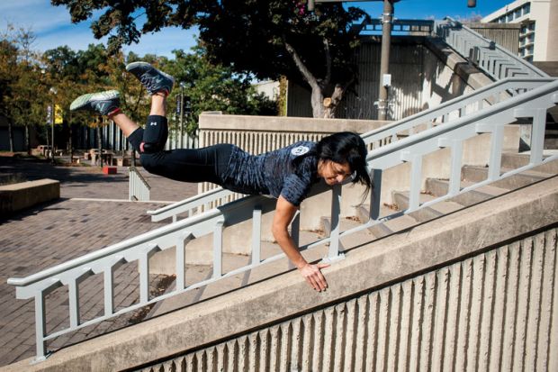 A lady vaults over a stair railing A lady vaults over a stair railing as a metaphor for a quarter of US states ‘likely to skip’ Biden free college plan