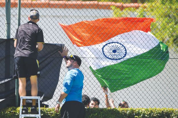 The Indian flag flies as ground staff erect netting in front as a metaphor that  Some Antipodean universities face an existential threat from the loss of Indian students.