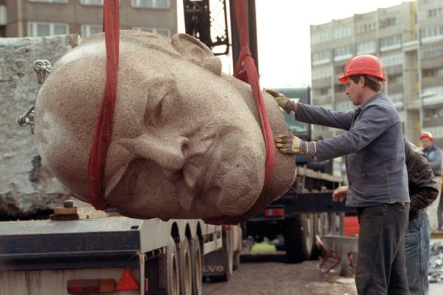 Worker removing the head of a statue representing late Soviet leader Vladimir Ilyich Lenin to represent Amid war, Russian 101 enrolments plummet at Western institutions