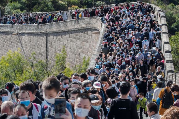 People crowd in a bottleneck as they move slowly on a section of the Great Wall at Badaling to illustrate  Overseas students struggle to get documents to return to China