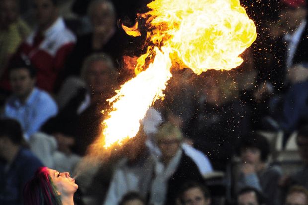 A fire-eater entertains the crowd to illustrate Australian international education blows hot and cold