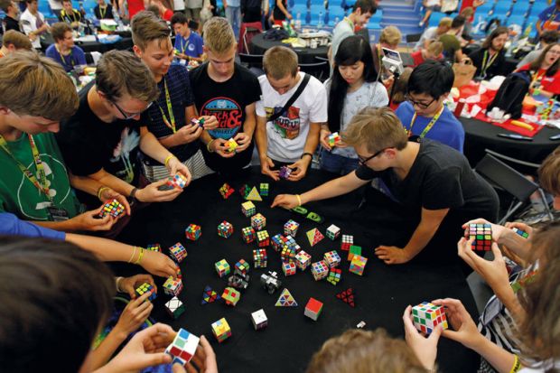 Competitors solve Rubik's cubes to illustrate Restoring trust in university learning is child’s play