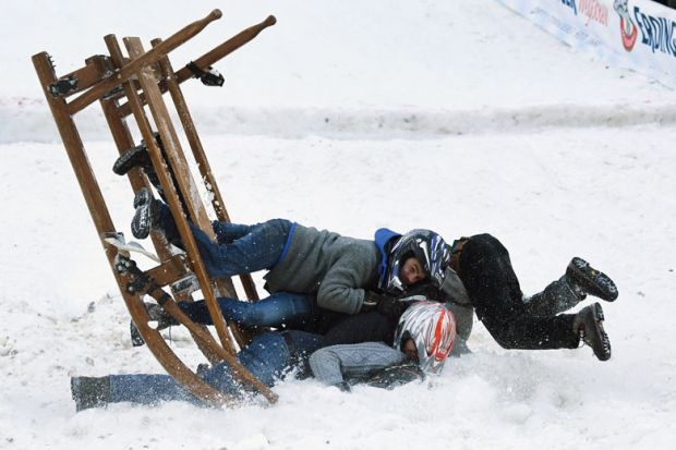 Participants of a sledge race fall in Garmisch-Partenkirchen, southern Germany to illustrate EU drops limit on fixed-term contracts but sector concerns remain