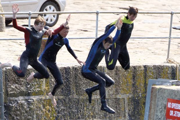 Four people jumping off from a harbour wall as a metaphor for cutting English fees and student numbers.