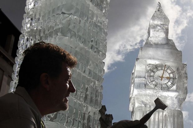 British ice sculptor Duncan Hamilton with his sculpture of London's iconic Big Ben to illustrate No Westminster government will raise fee cap, universities warned