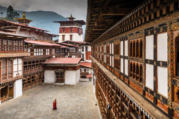 Single Monk in courtyard of Trongsa Dzong to illustrate Brain drain fears as Bhutanese head down under for degrees