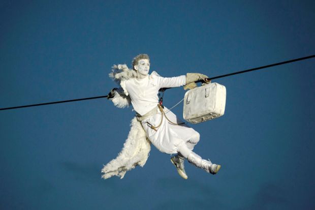 A performer is suspended from high-wires during the outdoor aerial performance of  a show