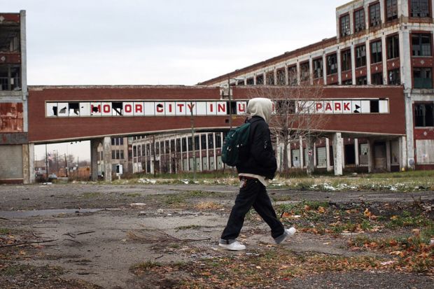 a person walks past the remains of the Packard Motor Car Company, which ceased production in the late 1950`s