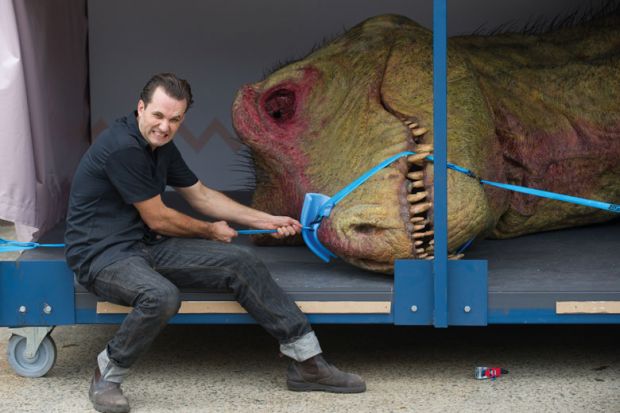 Staff ties a model T-Rex dinosaur around it's mouth to illustrate Student debt  starts to bite  in Australia