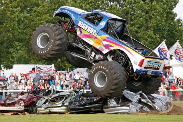 Monster truck driving over and flattening cars to illustrate DeSantis ‘wants to put trustees in charge of faculty hiring’