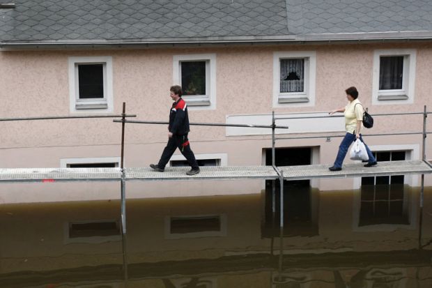 People walking on a tempory bridge in Germany People walking on a tempory bridge in Germany as a metaphor for precariously employed German academics