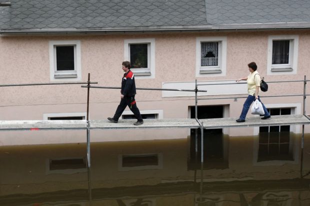 People walking on a tempory bridge in Germany as a metaphor for precariously employed German academics