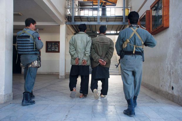 Afghan policemen escort two suspected Taliban in Herat to illustrate ‘I was beaten daily’: Afghan scholar recounts Taliban torture