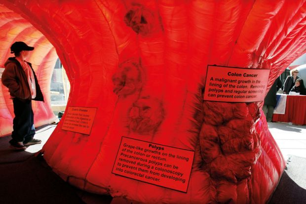 Boy stands inside an interactive replica of a human colon to illustrate Funding and careers structures are holdi  ng back early cancer detection