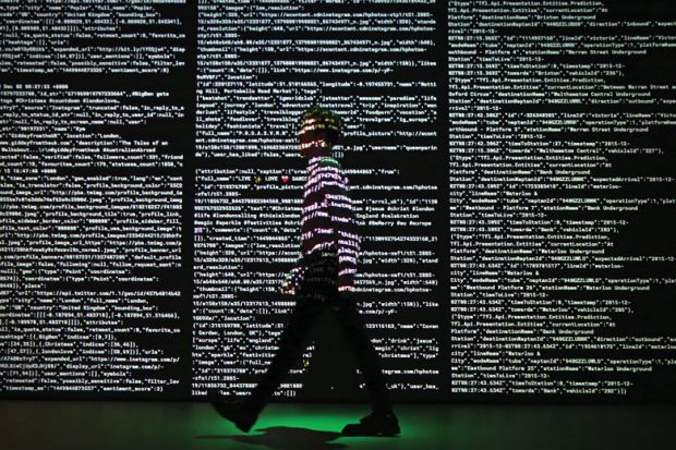 Person stands in a projection of live data feeds.
