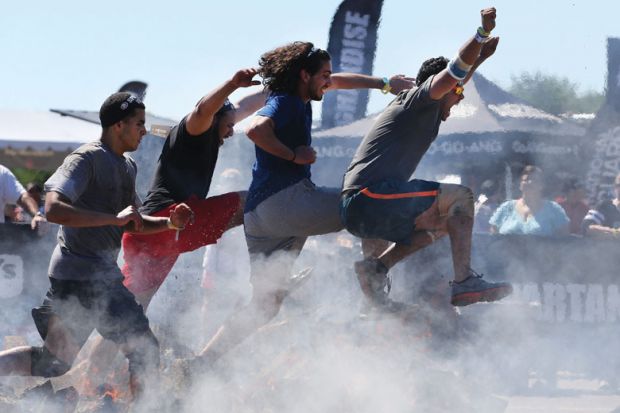 Competitors in action at the fire jump obstacle during the Reebok Spartan Race. Mohegan Sun, Uncasville, Connecticut, USA as a metaphor for the black colleges and universities (HBCUs) are on a run of rising public support, and student interest.