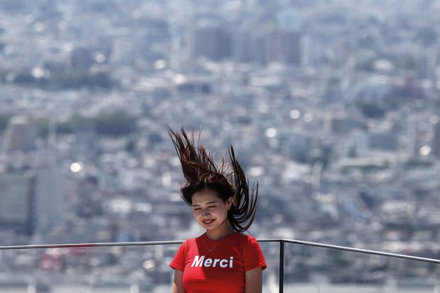 A woman poses for a picture with her hair blown upwards with the Tokyo skyline on the Shibuya Sky observation deck in Tokyo to illustrate ‘Sharp rise’ in science gender quotas at Japanese universities
