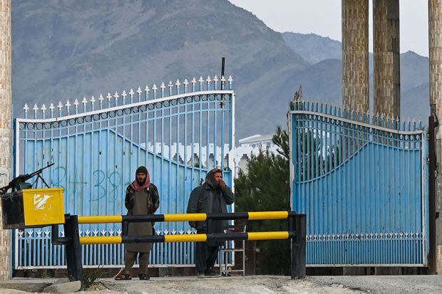Taliban fighters stand guard at the main gate of Laghman University in Mihtarlam to illustrate Afghan scholars fear creeping closure of universities