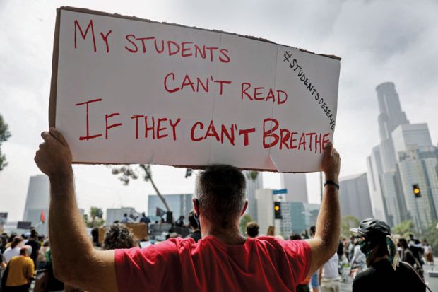 Protestor holding banner reading 'My students can't read If they can't breath. Protestor holding banner reading 'My students can't read If they can't breath for US college students battle alumni as they seek racial equity.