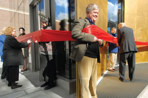 giant red ribbon encircling the Bowdoin College Museum of Art’s new building during a ribbon cutting ceremony  people cutting ribbon with adults holding it around them as a metaphor for what I've missed about my former life