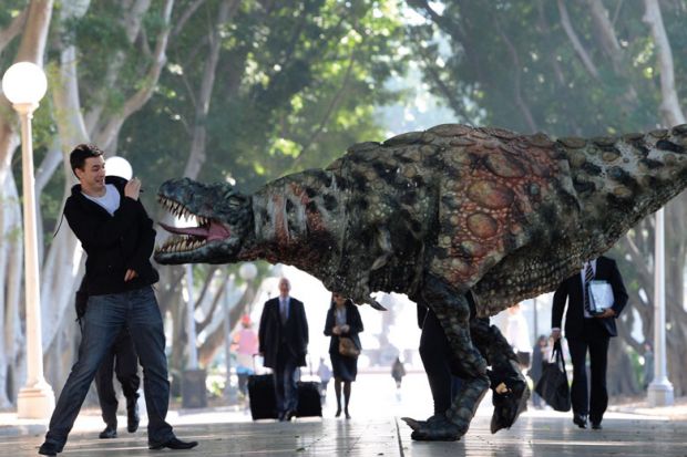 A Tyrannosaurus rex takes a morning stroll with commuters in Hyde Park n Sydney, Australia to illustrate Students protest against ‘predatory’ scholarship revocations