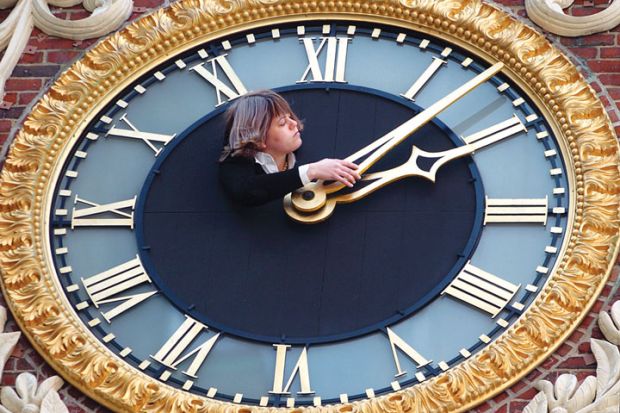 Lady adjusts the clock at the top of the Old State House to illustrate Students ‘could save £40K’ if they cancel gap years before reforms