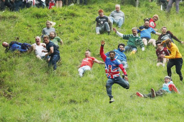 People taking part in the Cheese-Rolling downhill race in Gloucester, England to illustrate Entry rate fall creates ‘strategic uncertainty’ in English sector