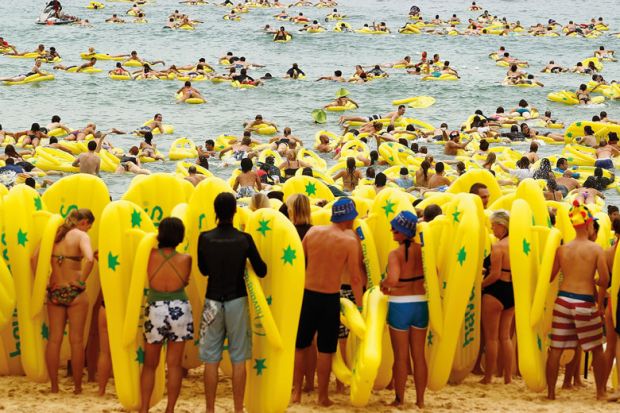 Beachgoers ride on inflatables with some waiting to go into the sea in Sydney, Australia to illustrate Two-step grant applications ‘will transform’ Australian research