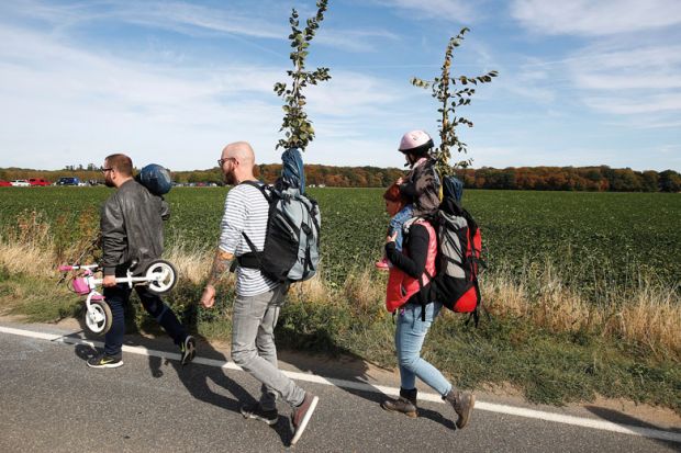three adults and one child walking