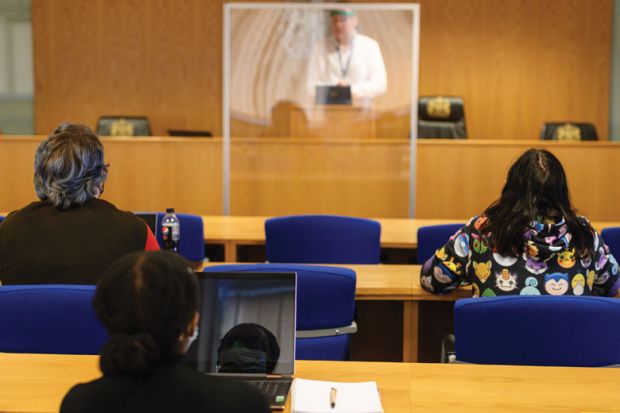 ecturer Ian Bowden teaches law students wearing face coverings to help mitigate the spread of the novel coronavirus .