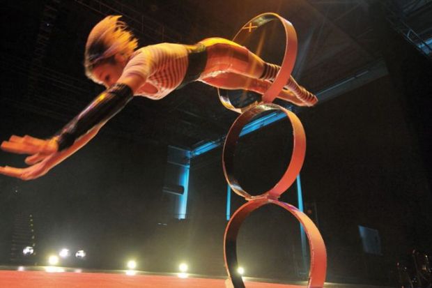 Girl jumps threw hoop at circus 