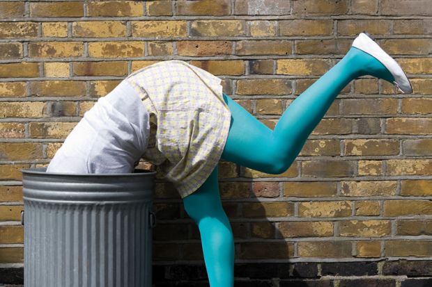 Woman diving into dustbin on street