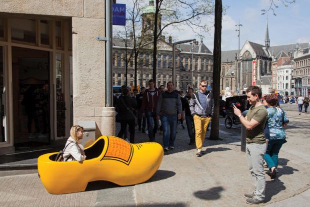 Woman sitting in giant yellow clog