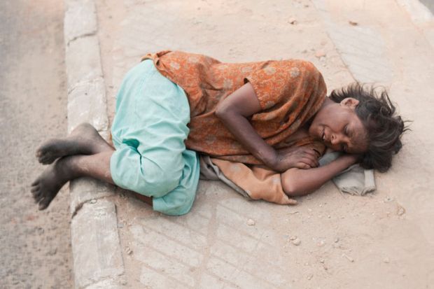 Woman lying on pavement, Delhi