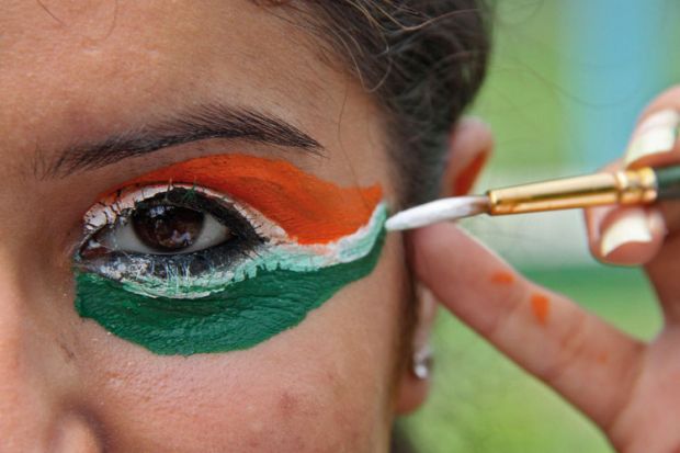 Woman painting eyes in colours of flag of India Woman painting eyes in colours of flag of India