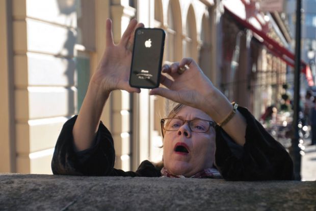 Woman taking photo using Apple iPhone smartphone