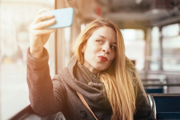 Woman taking selfie photograph with smartphone
